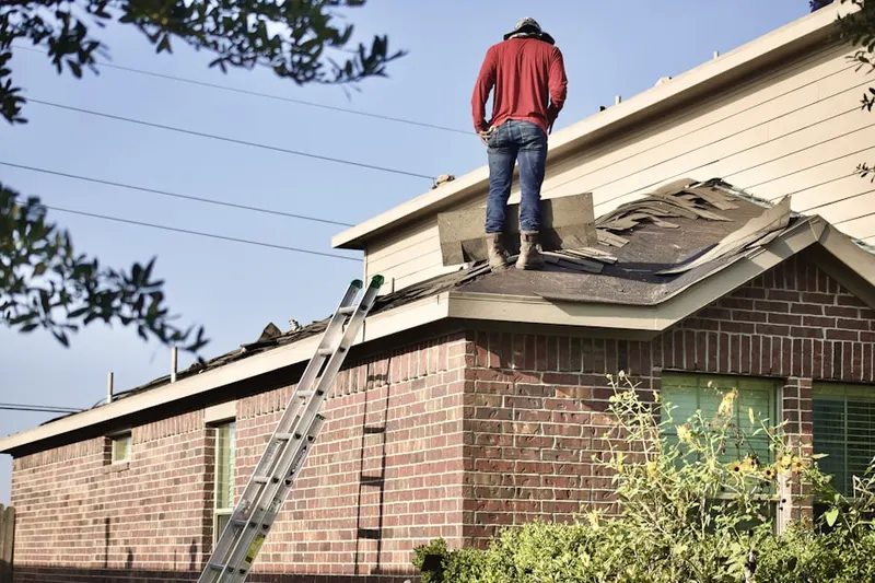 Professional roofer working on a residential roof in Quaker Neck Estates